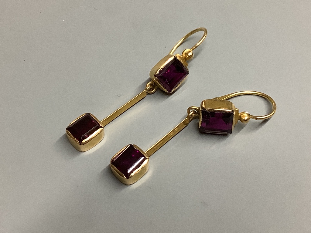 A pair of yellow metal and garnet set drop earrings